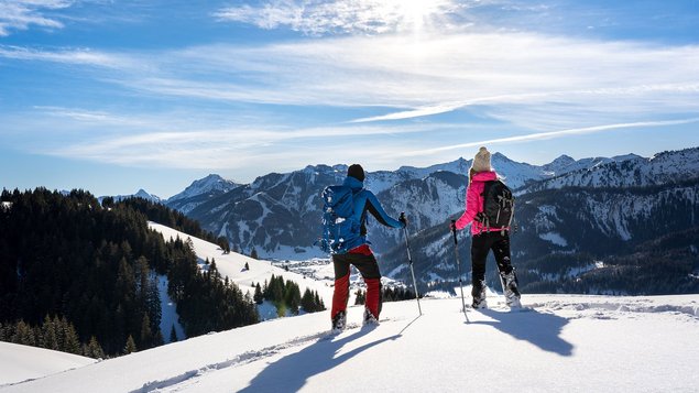 Zwei Skifahrer im Schnee vor Bergkulisse